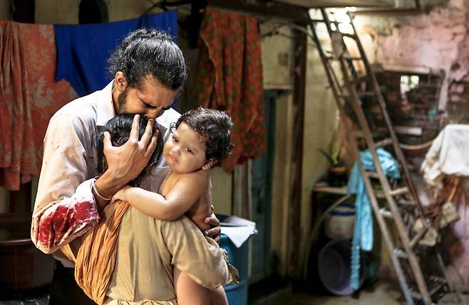 타지마할 호텔 직원 아르준이 테러 상황이 종료된 뒤 살아 돌아와 가족을 만나는 스틸컷. [에스와이코마드 제공]