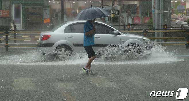 10일 오전 호우경보가 내린 부산 동래구 안락동의 한 도로에 물이 불어나 침수된 구간을 차량과 보행자가 힘겹게 지나가고 있다. 2020.7.10/뉴스1 © News1 여주연 기자