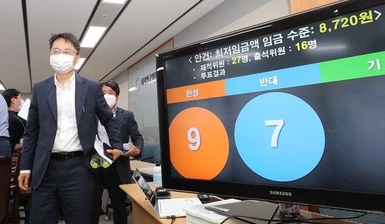 박준식 최저임금위원장(왼쪽)이 14일 새벽 세종시 정부세종청사 고용노동부에서 열린 제9차 최저임금위원회 전원회의 결과 브리핑을 마친 뒤 회의장을 나서고 있다.  이날 전원회의는 근로자위원들의 집단 퇴장으로 공익위원들이 낸 안으로 표결에 부쳐졌다. 찬성 9표, 반대 7표로 채택된 내년도 최저임금은 시급 기준 8천720원으로 최종 의결됐다. 연합뉴스.