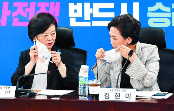 김현미(오른쪽) 국토교통부 장관이 15일 서울 여의도 국회 의원회관에서 수도권 주택공급 해결 방안 마련을 위한 부동산 대책 당정협의에 앞서 마스크를 벗고 있다. 왼쪽은 진선미 국회 국토교통위원장. 권현구 기자