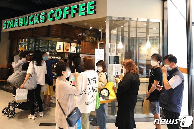 (서울=뉴스1) 황기선 기자 = 28일 서울 노원구 이마트타운 월계점 스타벅스 매장에서 고객들이 '서머e-프리퀀시' 이벤트를 위해 줄을 서 있다.   지난 21일 '세머e프리퀀시' 이벤트를 시작한 스타벅스는 증정품으로 캠핑용 의자와 여행 가방을 선보였다. 2020.5.28/뉴스1