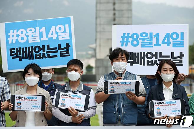 전국택배연대노조원들이 9일 오전 서울 세종대로 광화문광장에서 기자회견을 열고 8월14일을 택배 없는 날로 지정할 것을 촉구하고 있다. 이들은 이날 기자회견을 통해 '신종 코로나바이러스 감염증(코로나19) 장기화로 쉼 없이 일하며 올해만 3명이 과로로 사망했다'고 밝히고, 늘어난 물량에 휴식도 보장받지 못한 채 고된 노동에 시달리고 있다고 휴식 보장을 촉구했다. 또한 택배 없는 날 해시태그 달기·인증샷 등의 대국민 운동을 제안했다. 2020.7.9/뉴스1 © News1 이승배 기자