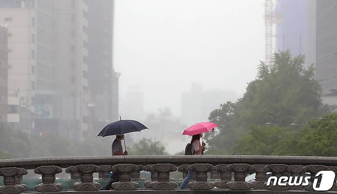 20일 오전 서울 중구 청계천 모전교에서 장맛비에 우산을 쓴 시민들이 발걸음을 옮기고 있다. 2020.7.20/뉴스1 © News1 구윤성 기자