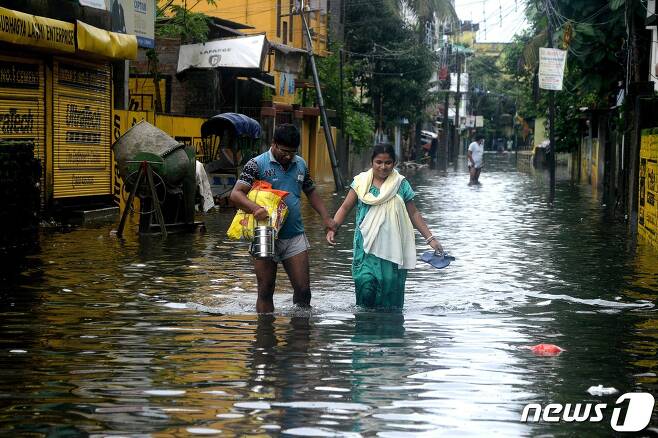 지난 12일 인도 웨스트벵골 주 실리구리에서 주민들이 홍수로 물에 잠긴 도로를 건너고 있다. © afp=뉴스1
