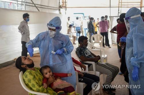 인도 아메다바드에서 코로나19 검사를 하는 의료진(가운데). [AFP=연합뉴스]