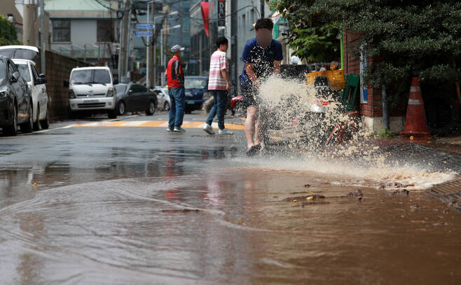 7월24일 오후 부산 동구 부산역 일대가 밤사이 내린 집중호우로 인해 진흙으로 뒤덮여 있다. 시민들이 배수펌프를 이용해 물을 빼내고 있다. ⓒ 연합뉴스