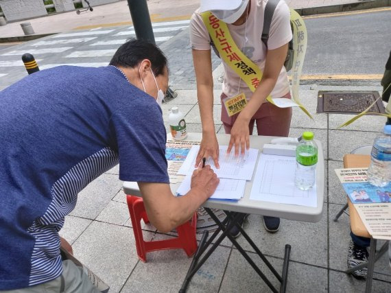 25일 오후 서울 중구 예금보험공사 앞에서 열린 '소급적용 남발하는 부동산 규제 정책 반대, 전국민 조세 저항운동 촛불집회' 참석자들이 최근 부동산 규제안에 반대하는 국민청원에 서명을 하고 있다. 사진=서혜진기자