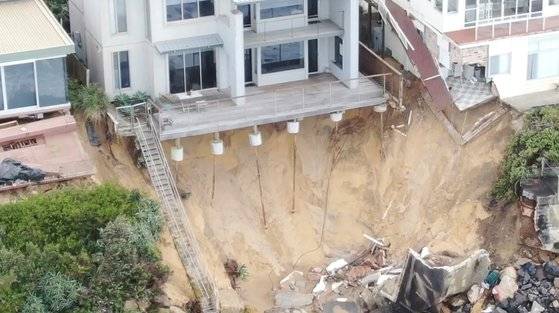 호주를 비롯한 세계 곳곳이 온난화에 따른 기후 변화로 해안 침식 현상을 겪고 있다. 지난 18일 호주 웜베럴 해안에 위치한 한 주택이 침식 현상으로 지반을 훤히 드러낸 모습. [로이터=연합뉴스]