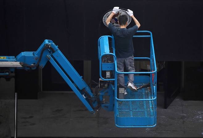 25일 중국 쓰촨성 청두에 위치한 미국 총영사관에서 크레인에 올라탄 작업자는 영사관 외벽에 붙은 미국 휘장을 제거했다. /사진=AFP