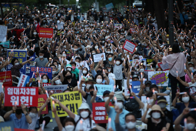 지난 25일 서울 중구 예금보험공사 앞에서 열린 ‘부동산 규제 정책 반대, 전 국민 조세저항운동 촛불집회’에서 참가자들이 정부의 부동산 대책에 반대하는 피켓을 들고 항의하고 있다. 이날 촛불집회에는 약 5,000명의 시민이 참가한 것으로 추산된다.  /연합뉴스