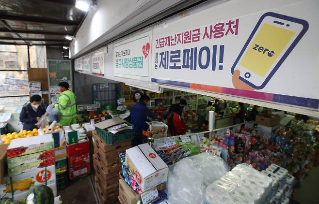 지난 5월 서울 중구 약수시장의 한 마트에 긴급재난지원금 사용 가능 안내문이 붙어 있다. 연합뉴스 제공