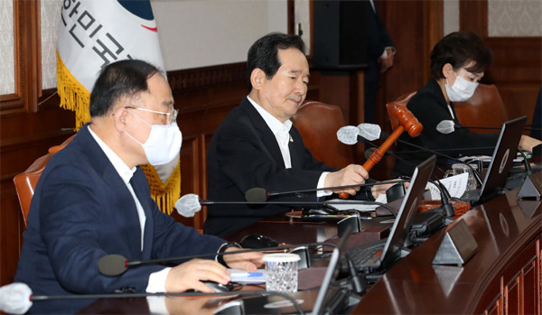 정세균 총리가 31일 오전 9시 40분 정부서울청사에서 열린 임시 국무회의에서 의사봉을 두드리고 있다. 왼쪽부터 홍남기 경제부총리, 정 총리, 김현미 국토교통부 장관. [한주형 기자]