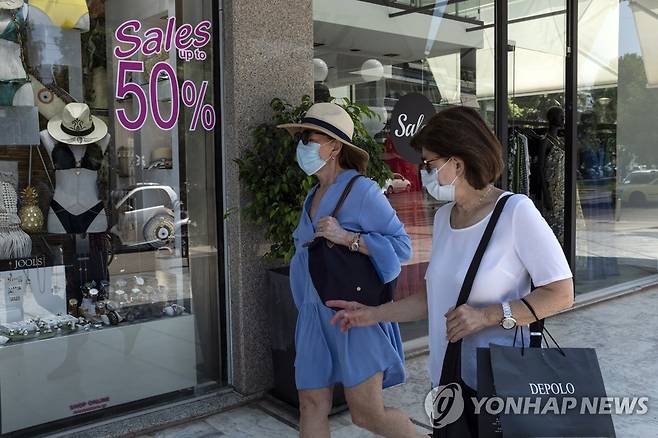 그리스 아테네에서 마스크를 쓴 채 상점 앞을 지나는 행인. 2020.8.1. [AP=연합뉴스]