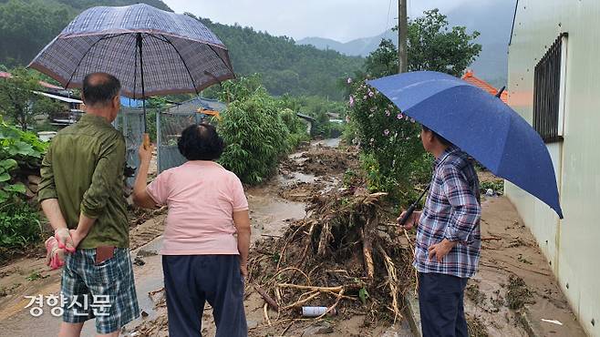 3일 오전 충북 충주시 산척면 송강리 광동마을 주민들이 폭우로 산사태 피해를 입은 마을 복구 현장을 지켜보고 있다.