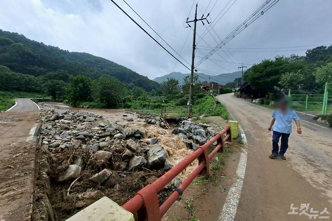 기록적인 폭우로 산사태가 발생한 아산 송악면 유곡리 마을 하천을 한 주민이 바라보고 있다.(사진=인상준 기자)