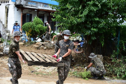 육군 37사단 70여명의 장병이 장갑을 끼고 마스크를 착용한 채 토사에 휩싸인 주택을 정리하고 있다. 충북도 제공