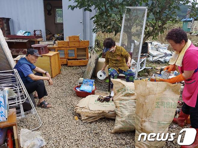 9일 오후 전남 구례군 광평마을에서 주민들이 침수 피해를 입은 집을 복구하다 지쳐 앉아있다. 이 마을 주민 대부분 70~90세의 고령층이라 복구 작업에 난항을 겪고 있다.2020.8.9/뉴스1 © News1