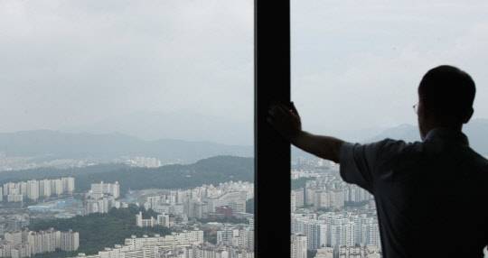 한 시민이 서울 여의도 63스카이아트에서 동작구 일대 아파트 단지를 바라보고 있다.<연합뉴스>