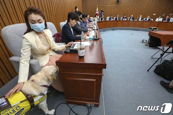 지난 5월26일 국회에서 열린 미래한국당 국회의원·당선인 합동회의에서 김예지 당선인이 안내견 조이를 달래고 있다./사진=뉴스1