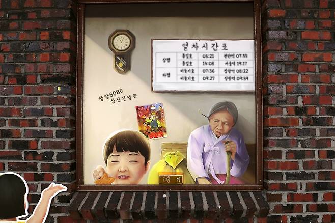 옛 장항선의 간수 초소에 있는 벽화. 그림 하단을 자세히 보면 금괴가 붙어 있다. 옛 장항역인 도시탐험역에서 이렇게 주변 곳곳에 숨겨진 금덩어리를 휴대전화로 찍어 내면 상품을 준다. [사진/조보희 기자]