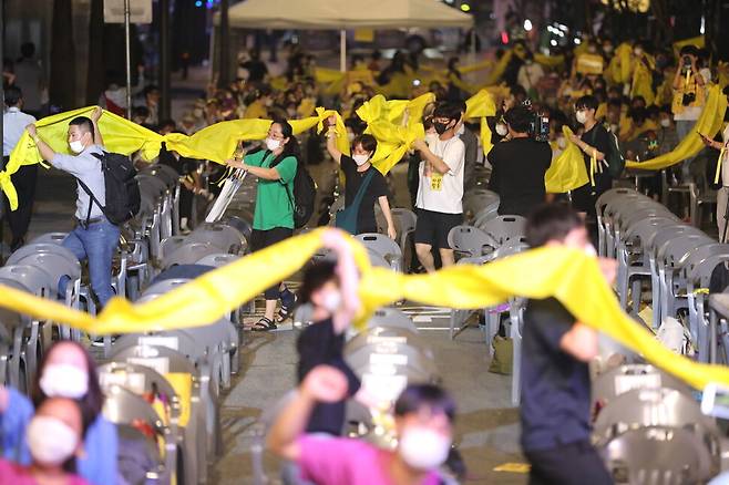 제8차 세계 일본군 `위안부' 기림일 나비문화제가 14일 오후 서울 종로구 서린동 광통교 인근에서 열려 참가자들이 노란끈을 묶어 무한대 상징을 만드는 행위극을 하고 있다. 이정아 기자