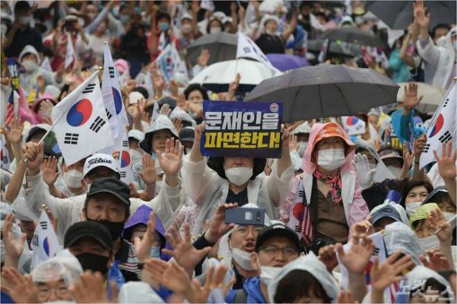 15일 오후 서울 종로구 동화면세점 앞에서 열린 보수단체의 광복절 집회에서 참서자들이 태극기와 문재인 대통령 파면을 촉구하는 피켓을 들고 있다. 이한형기자