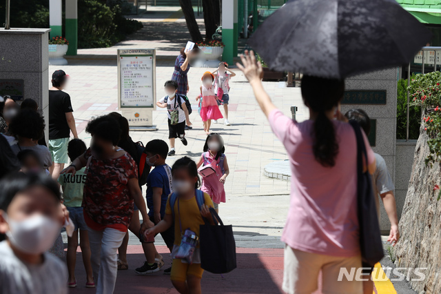 [서울=뉴시스] 고승민 기자 = 교육부가 오는 26일부터 서울 등 수도권 유치원, 초중고(고3 제외) 학교의 등교를 약 3주간 중단하고 원격수업으로 전환한다고 발표한 25일 서울의 한 초등학교에서 1, 2학년 학생들이 하교하고 있다. 이에 따라 교육부는 안정적인 원격수업을 위한 인프라와 원격수업 학습콘텐츠 지원을 강화한다. 2020.08.25.kkssmm99@newsis.com