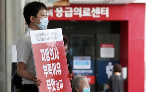 지난 26일 서울대병원 응급의료센터 앞에서 파업에 동참한 전임의가 문재인정부 의료 정책에 반대하는 피켓 시위를 하고 있다. 뉴시스