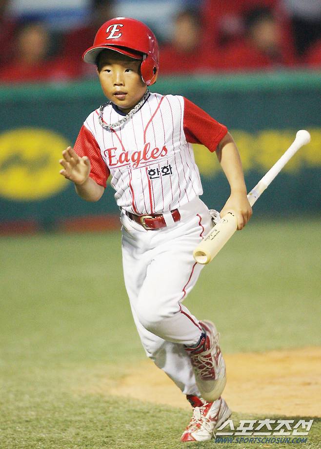2006년 6월 7일 경기에서 볼보이로 경기에 나선 송우현이 방망이를 들고 힘차게 그라운드를 질주하고 있다.