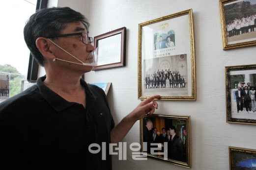 노무현 전 대통령 시절 체육계 인사들과 청와대를 찾아 기념촬영했던 사진을 보여주고 있다.(사진=정재훈 기자)