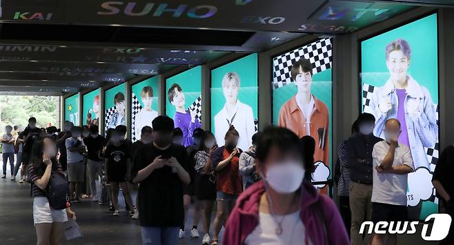 서울 중구 롯데면세점에 BTS의 광고판 앞으로 길게 줄을 서 대기하고 있다.  © News1