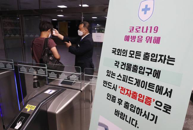 6일 오전 서울 여의도 국회의사당 입구에서 출입자가 발열검사를 받고 있다. [뉴스1]