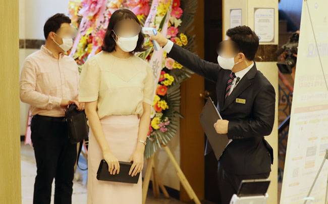 8월 29일 서울 강남구 한 웨딩홀에서 하객들이 입장 전 체온을 측정하고 있다. [뉴스1]