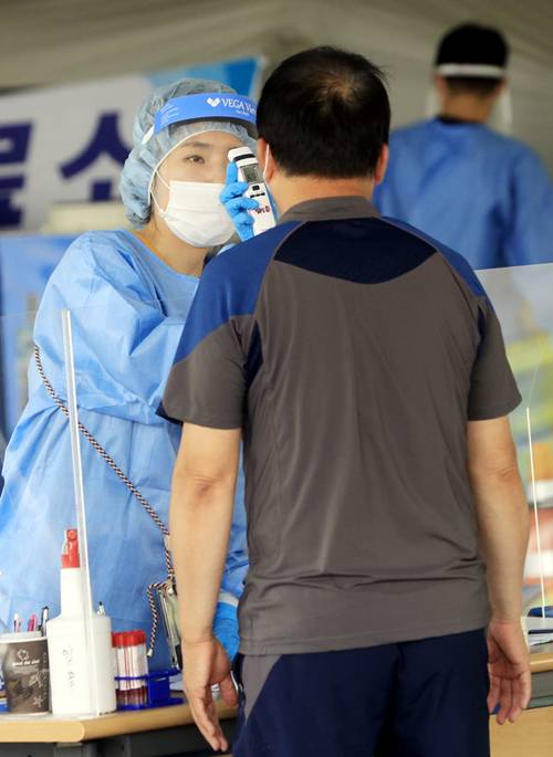 7월 19일 광주 서구청에 마련된 코로나19 선별진료소에서 한 시민이 피부적외선체온계로 체온 검사를 받고 있다. [ 박영철 동아일보 기자]