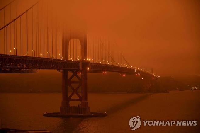 산불 연기로 붉게 변한 대기 속에 보이는 샌프란시스코 금문교 [AFP=연합뉴스]