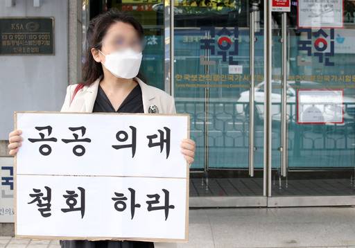 지난 10일 오후 한 전공의가 서울 광진구 한국보건의료인국가시험원 본관 앞에서 공공의대 정책 철회를 요구하는 1인 시위를 하고 있다. 정부는 의과대학생들이 의사 국가시험을 스스로 거부하고 있는 상황에서 추가 시험 등은 가능하지 않다는 입장이다. 뉴시스