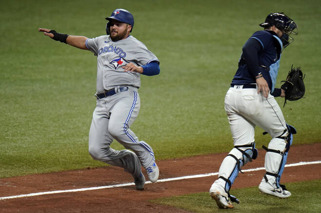 Toronto Blue Jays' Rowdy Tellez, left, scores behind Tampa Bay Rays catcher Mike Zunino on a sacrifice fly by Bo Bichette during the eighth inning of Game 1 of a wild card series playoff baseball game Tuesday, Sept. 29, 2020, in St. Petersburg, Fla. (AP Photo/Chris O'Meara)







<저작권자(c) 연합뉴스, 무단 전재-재배포 금지 >