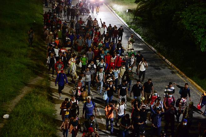 온두라스 이민자들이 1일(현지시간), 온두라스 산 페드로 술라에서 과테말라 국경을 향해 걷고 있다.(Photo by ORLANDO SIERRA / AFP)