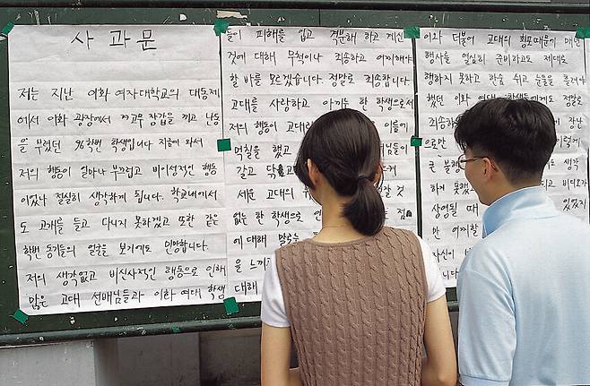 결국 고대생은 이화여대에 사과문을 남겼다. “저는 지난 이화여자대학교의 대동제에서 이화광장에서 고무장갑을 끼고 난동을 부렸던 96학번 학생입니다”라고 적혀 있다. 이화여대 학생이 이를 읽고 있다. 가해자는 고려대의 이름에 먹칠했다는 점을 후회하고 있다. 이 사진은 1996년 6월 <한겨레21>에 실렸다. 박승화 기자가 촬영했다.