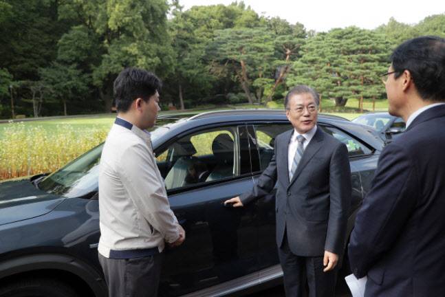 문재인 대통령이 지난해 8월 청와대 녹지원 앞에서 대통령 전용차로 도입된 수소차 ‘넥쏘’에 대한 설명을 듣고 있다. (사진=청와대 제공