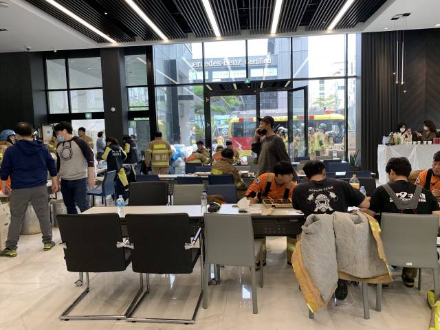 9일 오전 울산 남구 달동 벤츠 딜러사 스타자동차 영업점에서 삼환아르누보 화재를 진압하던 소방관들이 식사를 하고 있다./사진제공=스타자동차
