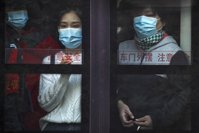 지난달 26일 중국 수도 베이징에서 출근길 시민들이 만원버스 안에서 마스크를 쓰고 있다. 베이징/AP 연합뉴스