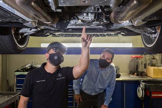 미국 메르세데스 벤츠 직원이 홀로렌즈2를 이용해 원격으로 전문가의 지침을 받아 자동차를 수리하고 있다. [사진 마이크로소프트]