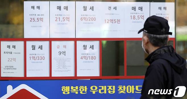 서울 한 공인중개업소 앞에 붙은 매물 정보를 지나가던 시민이 살펴보고 있다. /사진제공=뉴스1