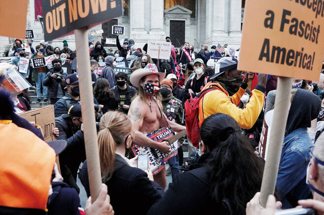 '벌거벗은 카우보이'로 알려진 트럼프 지지자 로버트 버크가 11월4일(현지시간) 뉴욕에서 열린 '모든 표를 집계하라' 집회에서 시위대와 대치하고 있다. ⓒREUTERS