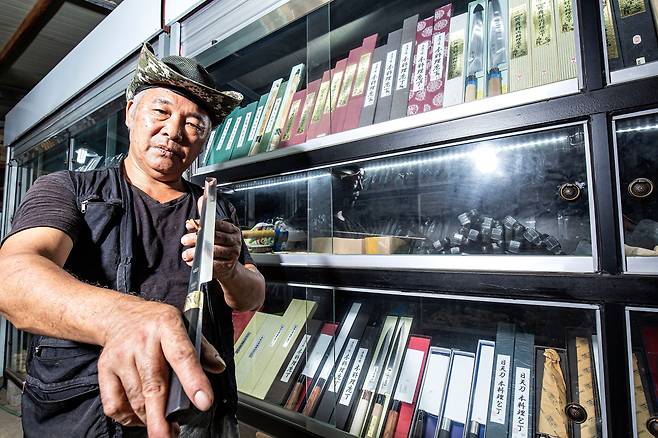 전만배씨가 한밭대장간에서 생산한 ‘한칼’ 브랜드 칼을 들어 보이고 있다. 칼 몸통에 '田'자와 방패 모양 한칼 로고가 새겨져 있다./김종연 영상미디어 기자