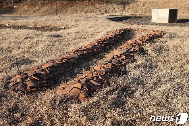 1974년 북한이 복원한 정릉사 보광전 뒤쪽에 있는 고구려시기 우물과 출토 기와 조각들. (미디어한국학 제공) 2020.11.14.© 뉴스1