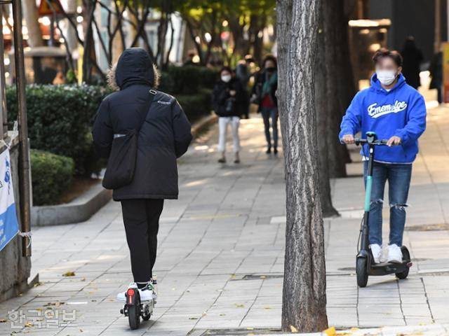 3일 서울 강남구 역삼역 옆 보행도로에서 공유 전동 킥보드 탑승자 두명이 서로를 가로지르고 있다. 한국일보 자료사진