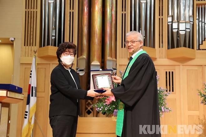 남대문교회 손윤탁 목사가 정여임 목사에게 수상 기념패를 전달하고 있다.
