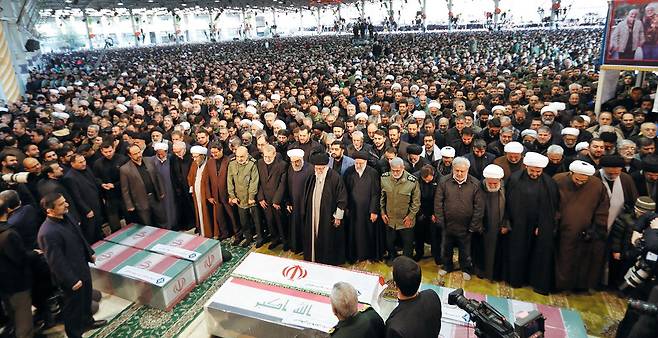 6일 아야톨라 알리 하메네이(앞줄 가운데 검은 모자) 이란 최고 지도자와 하산 로하니(그 왼쪽) 대통령 등 정권 수뇌부가 미군의 드론 공격으로 사살된 가셈 솔레이마니 전 쿠드스 사령관 등의 장례식장이 차려진 테헤란대학교에서 사망자들의 관에 참배하고 있다.